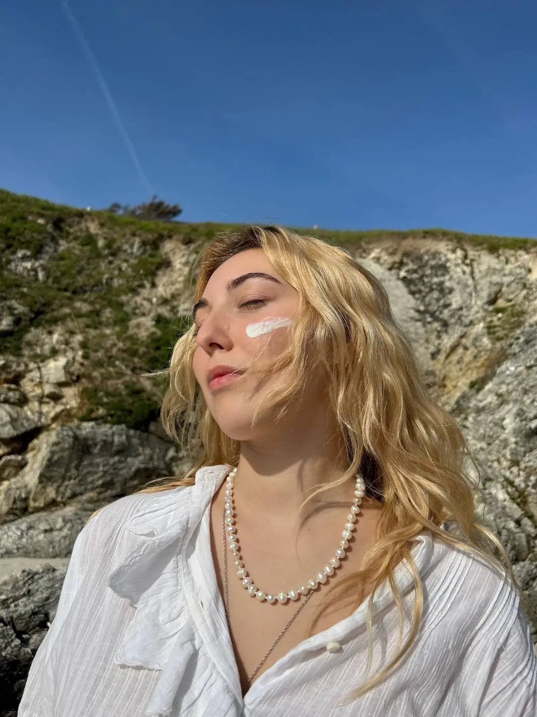 Jolie blonde qui bronze en toute sécurité grâce à notre Fluide Solaire SPF50