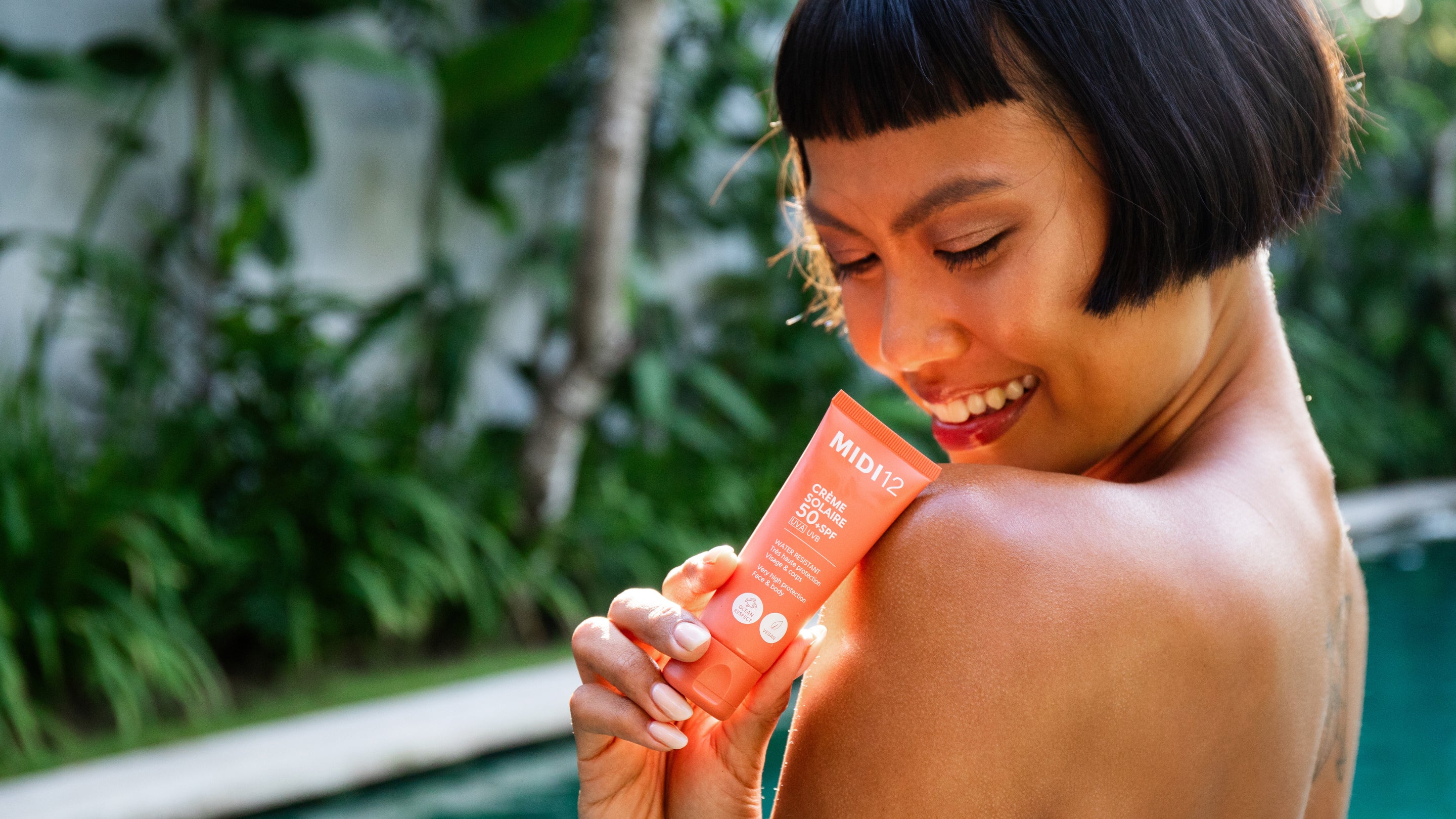 Femme et crème solaire au bord de la piscine